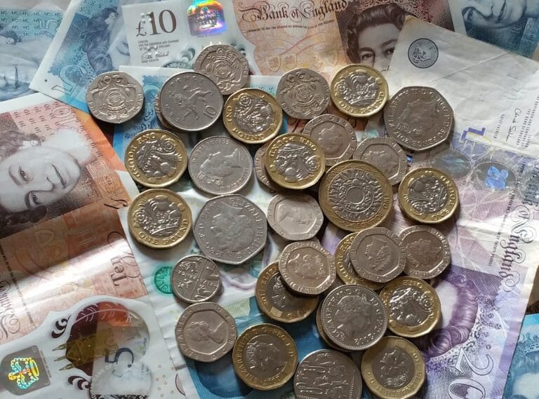 Billetes y monedas de libras esterlinas representando la tarifa del UK ETA