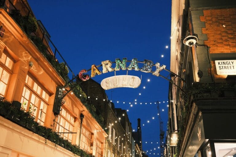 Illuminated Carnaby Street sign in Soho, London, showcasing vibrant nightlife at