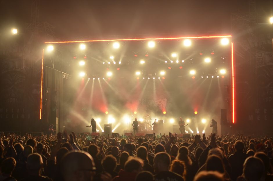 Escenario iluminado y multitud disfrutando de un concierto nocturno en una sala londinense