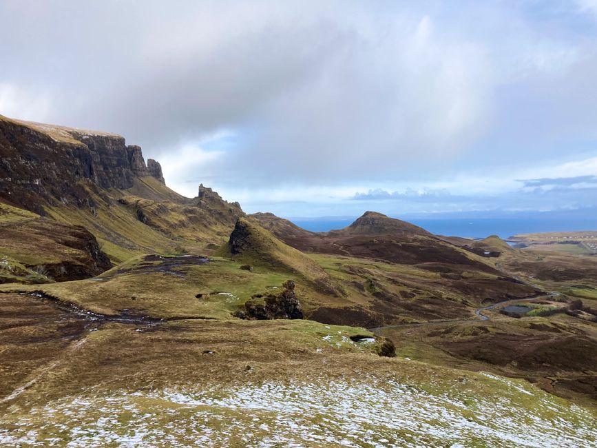 Paisaje de la isla de Skye con montanas verdes escarpadas y cielo nublado en Escocia