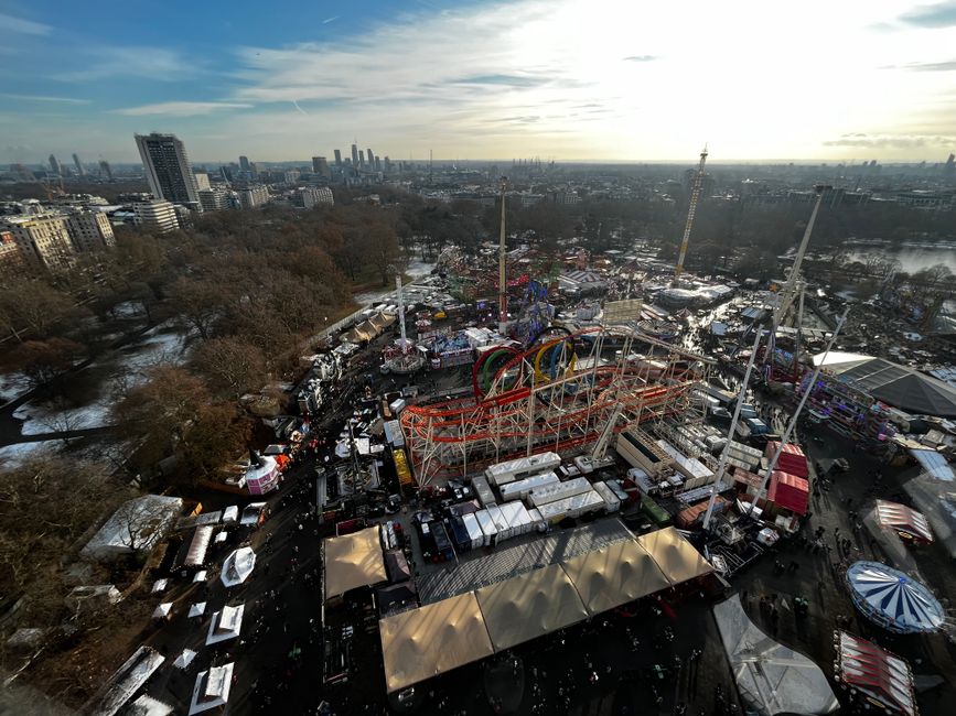 Puestos iluminados y noria del mercado navideño Winter Wonderland en Hyde Park de noche
