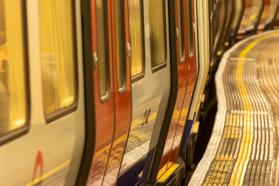 Viajero consultando el horario del metro de Londres en su móvil en el andén
