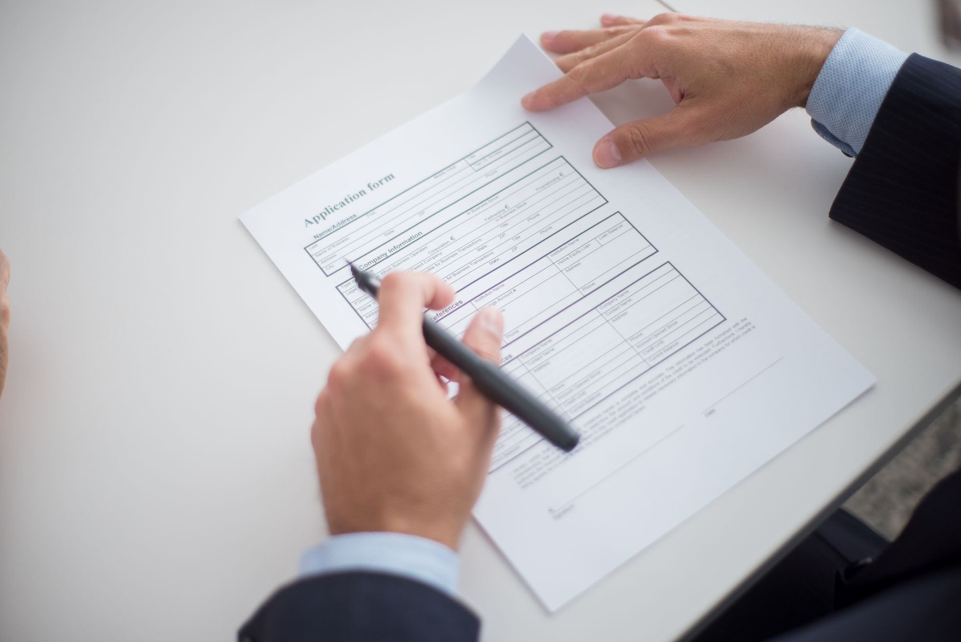 Persona rellenando un formulario de solicitud con el pasaporte al lado para copiar los apellidos en la ETA