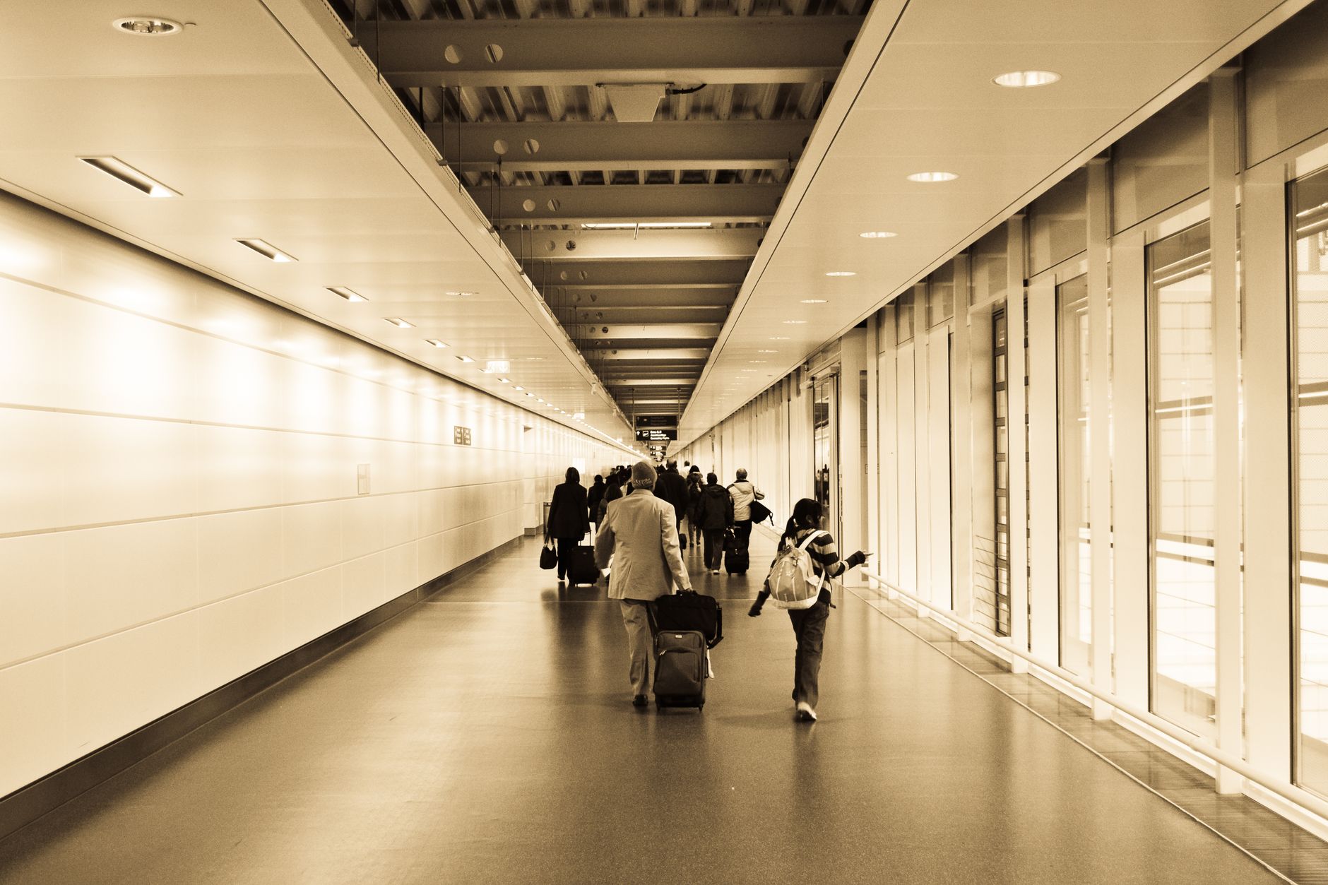 Viajeros con maletas cruzando deprisa la terminal de salidas de un aeropuerto