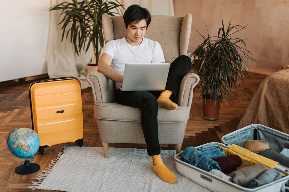 Viajero tranquilo planificando su viaje con el portátil en casa