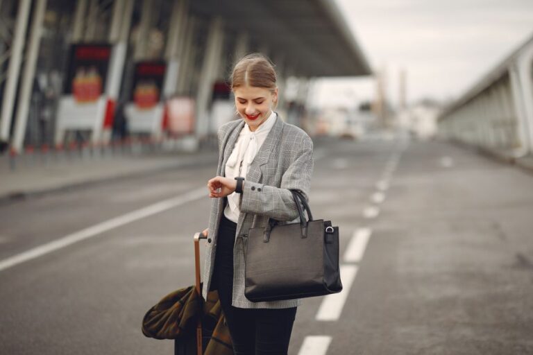 Viajera con maleta usando el móvil en la terminal del aeropuerto poco antes de embarcar en 2026